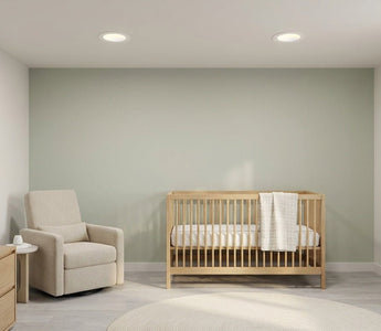 Calm American nursery lit by slim canless LED recessed downlights — safe, dimmable warm-white lighting for baby sleep